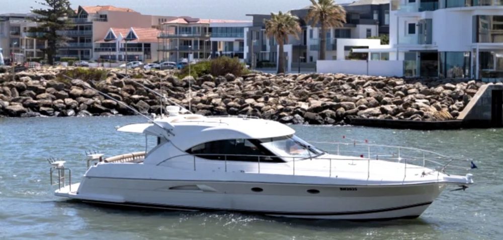 Riviera 4700 Sport Yacht cruising past waterfront homes
